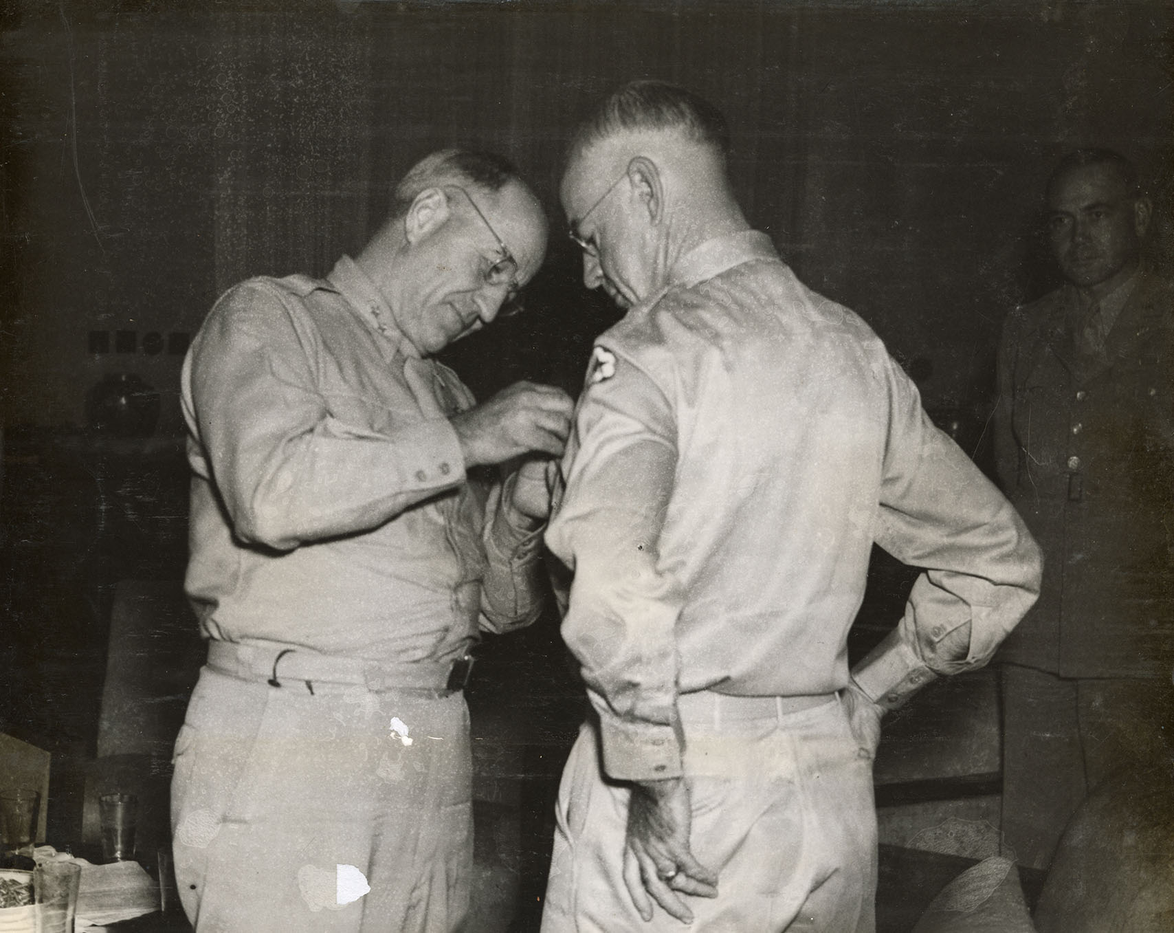 One officer pins a medal on another officer